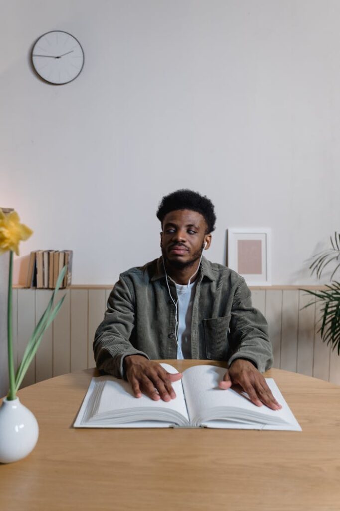 Crafting Captivating Headlines: Your awesome post title goes here A young blind man uses Braille at a table in a calm, indoor setting, embodying accessibility.